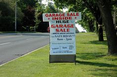 a garage sale sign is on the side of the road