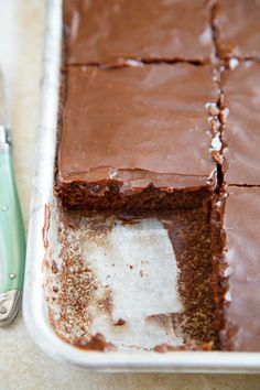 a chocolate cake sitting on top of a pan next to a knife