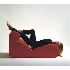 a woman laying on top of a red heart shaped chair