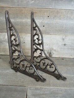 two cast iron shelf brackets with scroll designs