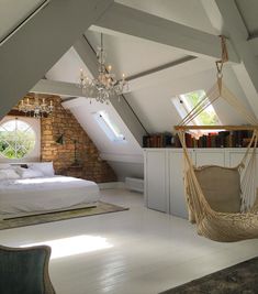 an attic bedroom with a hammock bed and chandelier hanging from the ceiling