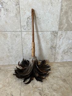 a feather duster sitting on top of a tiled floor