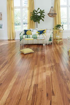 a living room with wood floors and yellow curtains