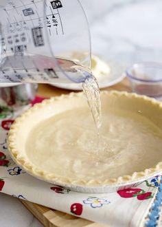 someone pouring water into a pie crust