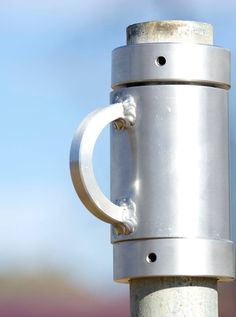 a close up of a metal object on a pole with sky in the back ground