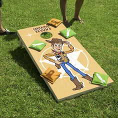 a person standing next to a cornhole game