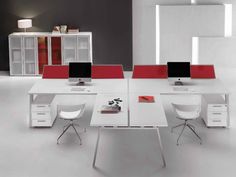 an office desk with two computer monitors on top of it and white chairs around it