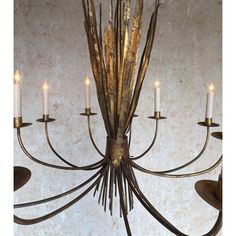 a chandelier with five candles hanging from it's arms and leaves in the center