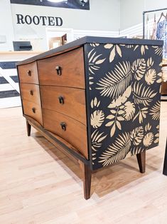 a black and white painted dresser on display in a store