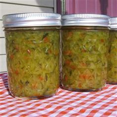 three jars filled with food sitting on top of a red and white checkered table cloth