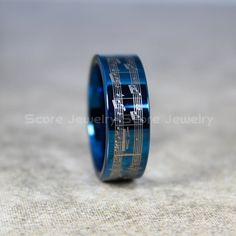 a blue ring with musical notes inlayed to it's center, sitting on a surface