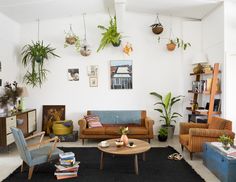 a living room filled with furniture and lots of plants