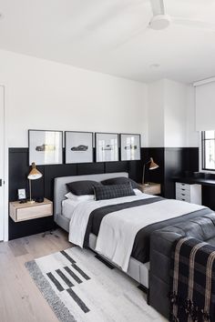 a bedroom with black and white decor, pictures on the wall, and a bed