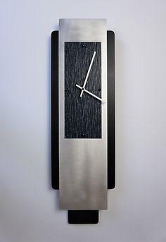 a clock that is mounted to the side of a wall with an arrow on it