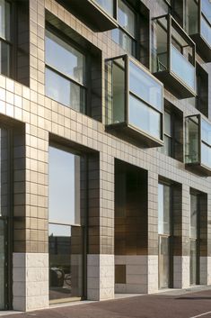 the building has many windows on it and is made of stone blocks with glass balconies