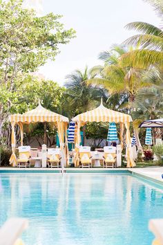 an outdoor swimming pool with chairs and umbrellas