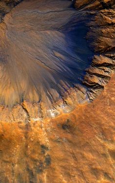 an aerial view of the earth's water and landforms, with brown patches on it