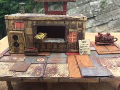 an old fashioned stove sitting on top of a wooden table next to other pieces of wood