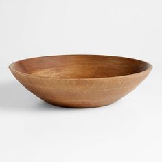 a wooden bowl sitting on top of a white table