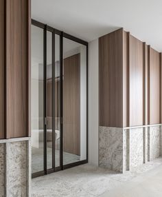 an empty room with marble walls and wooden paneling on the wall, along with glass doors