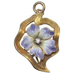 INDULGE IN A GORGEOUS VICTORIAN - ART NOUVEAU PENDANT NECKLACE WITH A BEAUTIFUL LAVENDER, CREAM AND BLUE ENAMEL FORGET-ME-NOT, OR PANSY FLOWER WITH AN OLD MINE CUT DIAMOND IN THE CENTER. THE FLOWER IS SET IN AN ELEGANT GOLD RIBBON SURROUND WITH LOVELY ART NOUVEAU DESIGN. THE PENDANT IS 14 KARAT YELLOW GOLD. THIS IS ONE OF THE MOST BEAUTIFUL ENAMEL FLOWER JEWELS WE HAVE SEEN. THE FLOWER IS BEAUTIFULLY RENDERED WITH GREAT DETAIL IN THE ENAMEL WORK ON EACH PETAL. THE PETALS HAVE WONDERFUL NATURALIS Art Nouveau Locket, Victorian Pendant Necklace, Motifs Art Nouveau, Lavender Cream, Diamond Pendant Jewelry, Letter Charm Necklace, Art Nouveau Necklaces, Forget Me Not Flowers, Pansy Flower