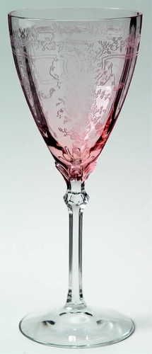 a pink wine glass sitting on top of a table