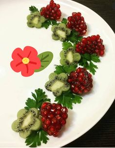 a white plate topped with kiwis and raspberries