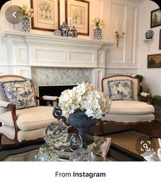 a living room filled with furniture and a fire place covered in white hydrangeas