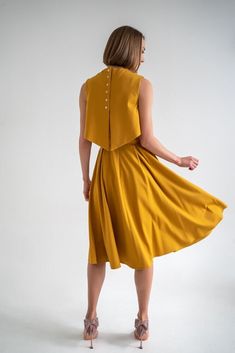 Mustard yellow dress consists of three parts - a top, an A-shaped skirt and an overtop. You can choose the top with or without the nursing option. The overtop is specially made for more discreet nursing but will also serve as an eye-catching accent even without the nursing option and will give you a well put together look. The dress has pockets and it can be transformed into three parts and worn separately so this set is perfect for traveling or as a sustainable piece in your capsule wardrobe. This timeless dress will live in your wardrobe forever due to the elegant and always-in-fashion fit. Materials: 60% viscose, 35% polyamide, 5% elastane, lining is made from 95% polyamide and 5% elastane. 34 = XS 36 = S 38 = M 40 = L 42 = XL 44 = XXL THIS DRESS CAN BE ORDERED BY STANDARD SIZING CHART Chic Sleeveless Mustard Midi Dress, Chic Mustard Sleeveless Midi Dress, Yellow Full Skirt Dresses For Summer, Mustard Summer Dresses For Workwear, Chic Mustard Dress For Work, Fitted Mustard Dress For Daywear, Mustard Chic Dress For Work, Chic Mustard Workwear Dress, Dark Yellow Dress