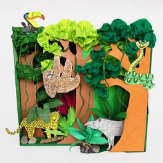 an image of jungle scene made out of paper with animals, plants and trees in the background