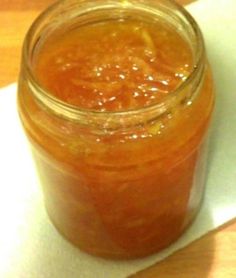 a glass jar filled with liquid sitting on top of a white paper towel next to a wooden table