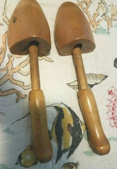 two wooden spatulas sitting next to each other on a tablecloth covered surface