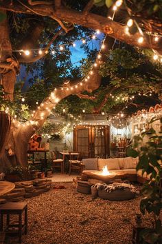 an outdoor living area with lights strung from the trees