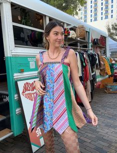 a woman standing in front of a food truck with her hand on her hip and looking at the camera