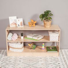 a shelf with books, toys and pictures on it in a child's room