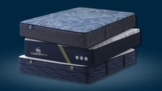 two mattresses stacked on top of each other in front of a dark blue background