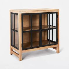 a wooden cabinet with glass doors on the front and bottom shelves in black metal trim