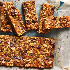 several pieces of fruit and nut bars on a piece of parchment paper