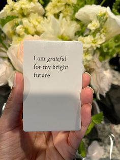 a person holding up a card with the words i am grateful for my bright future