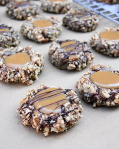 cookies with peanut butter and chocolate drizzled on top, lined up on a baking sheet