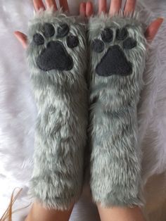 a pair of hands that are covered in furry animal paw mittens, with one hand on top of the other