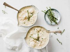 two bowls filled with food on top of a white table