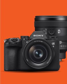 the sony camera is next to an orange background and there are two other cameras in front of it