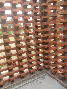 a wall made out of wooden blocks in the middle of a room with concrete flooring