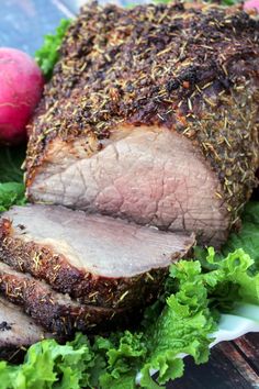 a piece of meat sitting on top of lettuce next to some radishes