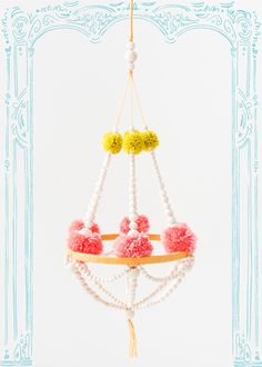 a white chandelier with pom - poms hanging from it's sides