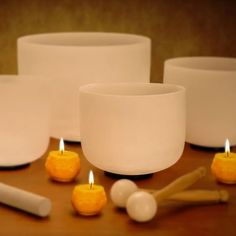 several white bowls and candles on a table