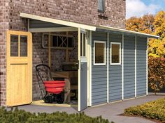 a garage with a red wheelbarrow in front of it and an open door