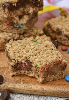 chocolate chip cookie bars on a wooden cutting board with m & m candies around them