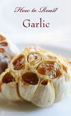 two garlic shells on a white plate with the words how to roast garlic